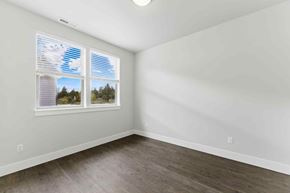 Bend apartment for rent - A room with a window showing a view of trees and a blue sky.