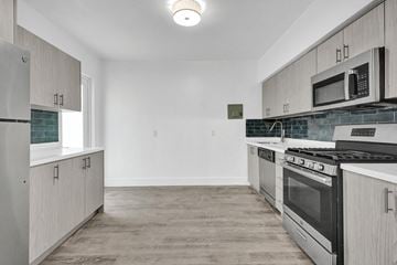 Bay Harbor apartment for rent - A kitchen with a black stove top oven and white cabinets.