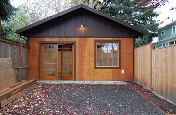 Portland apartment for rent - A small wooden house with a brown door and windows.