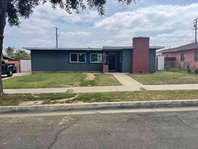 Santa Maria house for rent - A small building with a red brick chimney is situated on a street corner.