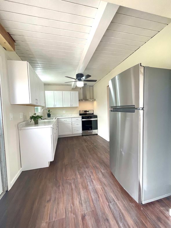 Santa Maria house for rent - A kitchen with a refrigerator on the right and a ceiling fan in the middle.