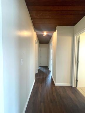 Santa Maria house for rent - A long hallway with wood floors and white walls.