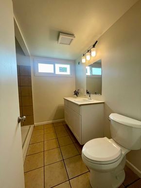 Santa Maria house for rent - A white toilet in a small bathroom with a white cabinet and a mirror above it.