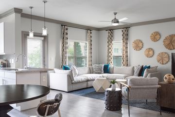 Overland Park apartment for rent - A modern living room with a white couch and a dining table.