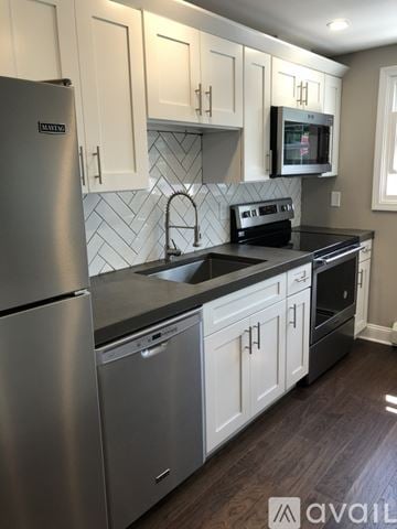 Buffalo apartment for rent - A kitchen with a stainless steel refrigerator and a black countertop.