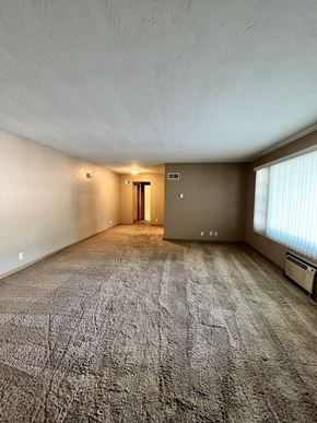 Lincoln apartment for rent - an empty living room with a large window and carpet