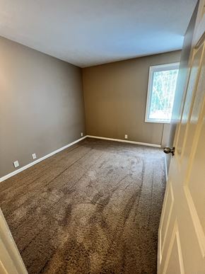 Lincoln apartment for rent - an empty bedroom with a carpeted floor and a window