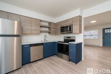 Coeur D'alene apartment for rent - A kitchen with blue cabinets and a stainless steel refrigerator.