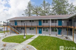 Coeur D'alene apartment for rent - A modern building with a green door and a gravel pathway in front.