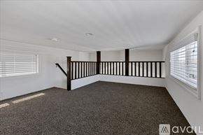 Barstow apartment for rent - A room with a carpeted floor and a staircase with wooden railings.
