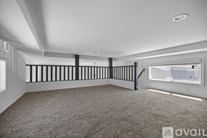 Barstow apartment for rent - A spacious room with a carpeted floor and a staircase with black railings.