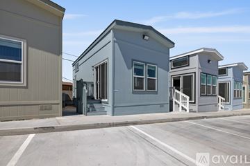Barstow apartment for rent - A kitchen with a refrigerator, microwave, and oven is in a house with a staircase.