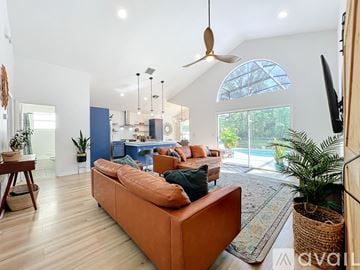 Lake Mary house for rent - A living room with a brown sofa and a ceiling fan.