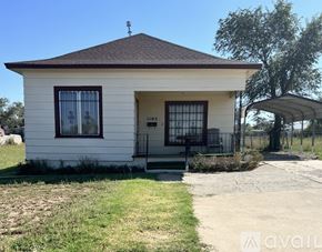 Amarillo house for rent - A small white house with a brown roof and a black gate.