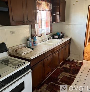 Amarillo house for rent - A kitchen with a white stove and brown cabinets.