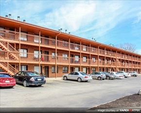 Lincoln apartment for rent - a parking lot with cars parked in front of a building