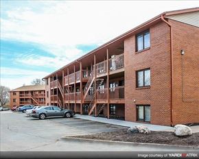 Lincoln apartment for rent - a brick apartment building with stairs and cars parked