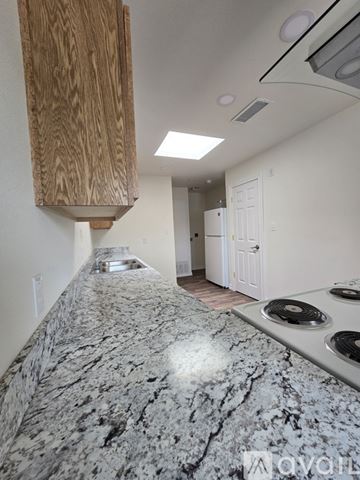 Roswell apartment for rent - A kitchen with a granite countertop and a wooden cabinet.