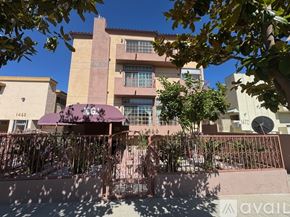Los Angeles apartment for rent - A building with a purple awning is in front of a tree.
