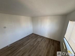 Fort Stockton apartment for rent - A room with wooden flooring and a window with blinds.