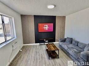 Fort Stockton apartment for rent - A living room with a grey couch, a wooden coffee table, and a flat screen TV mounted on the wall.