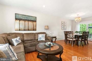 Silver Spring house for rent - A living room with a brown couch, a coffee table, and a painting on the wall.