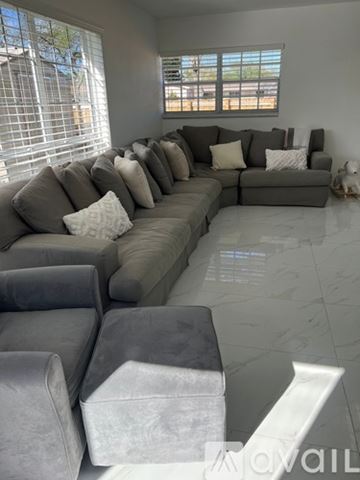 North Miami Beach house for rent - A living room with a grey couch and pillows.