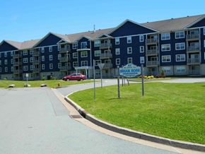 Dartmouth apartment for rent - A red car is parked in front of a blue apartment building.