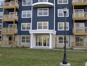 Dartmouth apartment for rent - A blue apartment building with a white door and a lamp post in front.