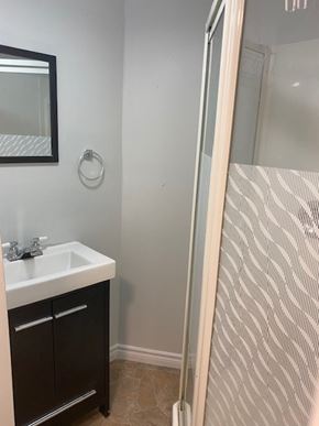 Halifax apartment for rent - A bathroom with a sink and a shower door.