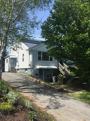 Halifax apartment for rent - A white house with a grey roof and a tree in front of it.