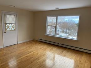 Halifax apartment for rent - A room with a wooden floor and a window showing a snowy landscape outside.