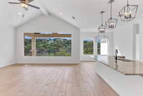 Horseshoe Bay house for rent - A spacious room with a ceiling fan and a view of a green landscape through a large window.