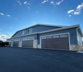 Belgium apartment for rent - A large two-story garage with a car parked in front.