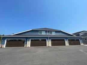 Belgium apartment for rent - A large blue building with four garage doors.