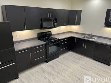 Mableton house for rent - A kitchen with black cabinets and appliances.