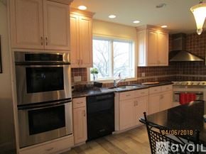 Revere house for rent - A kitchen with a black stove top oven and a black dishwasher.