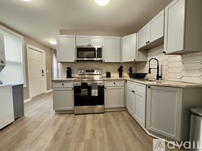 Troy apartment for rent - A kitchen with white cabinets and a wooden floor.