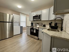 Troy apartment for rent - A kitchen with a refrigerator, microwave, oven, and sink.