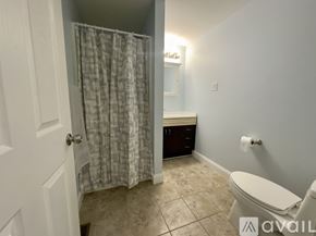 Troy apartment for rent - A bathroom with a toilet, sink, and shower curtain.