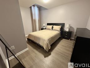 Troy apartment for rent - A bedroom with a large bed and a nightstand with a lamp.