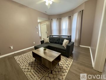 Troy apartment for rent - A living room with a black couch and a wooden coffee table.
