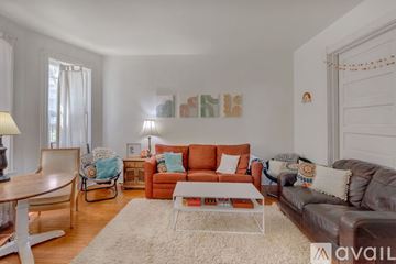 Charlottesville house for rent - A living room with a brown leather couch and a white coffee table.