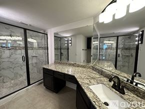 Rockwall condo for rent - A bathroom with a marble countertop and a sink.