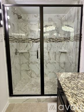 Rockwall condo for rent - A marble bathroom with a walk-in shower and a marble countertop.
