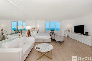 Miami Beach apartment for rent - A living room with white furniture and a flat screen TV.