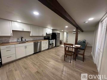 Whitefish apartment for rent - A kitchen with a black refrigerator and wooden beams on the ceiling.