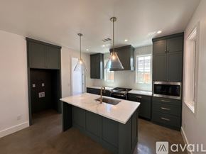 Oklahoma City house for rent - A kitchen with a white countertop and dark cabinets.