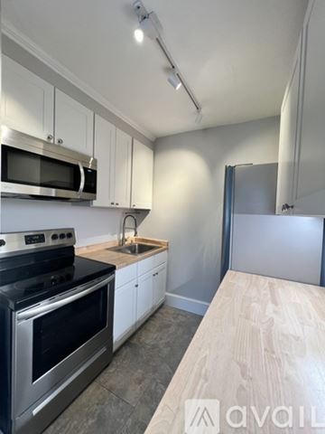Newmarket apartment for rent - A kitchen with white cabinets and a wooden countertop.