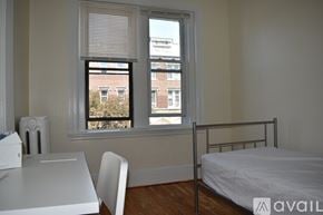 Boston apartment for rent - A bedroom with a bed, desk, chair, and window.